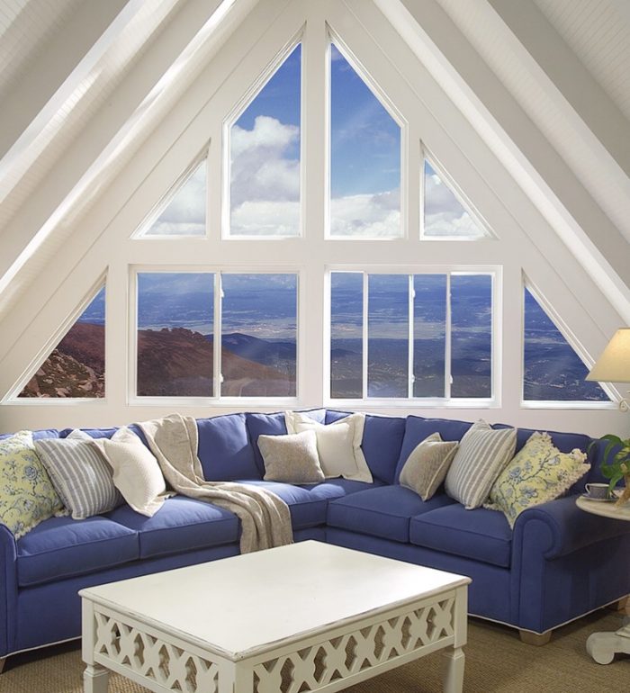 Blue sky visible through triangle-shaped sets of glass windows